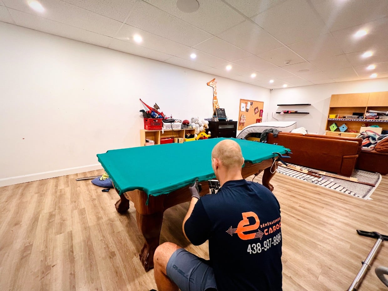 Meilleurs déménageurs déplaçant une table de billard dans un sous-sol